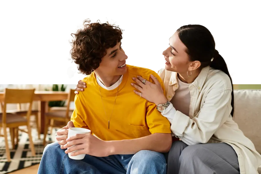 A parent and teenager talking together on a sofa